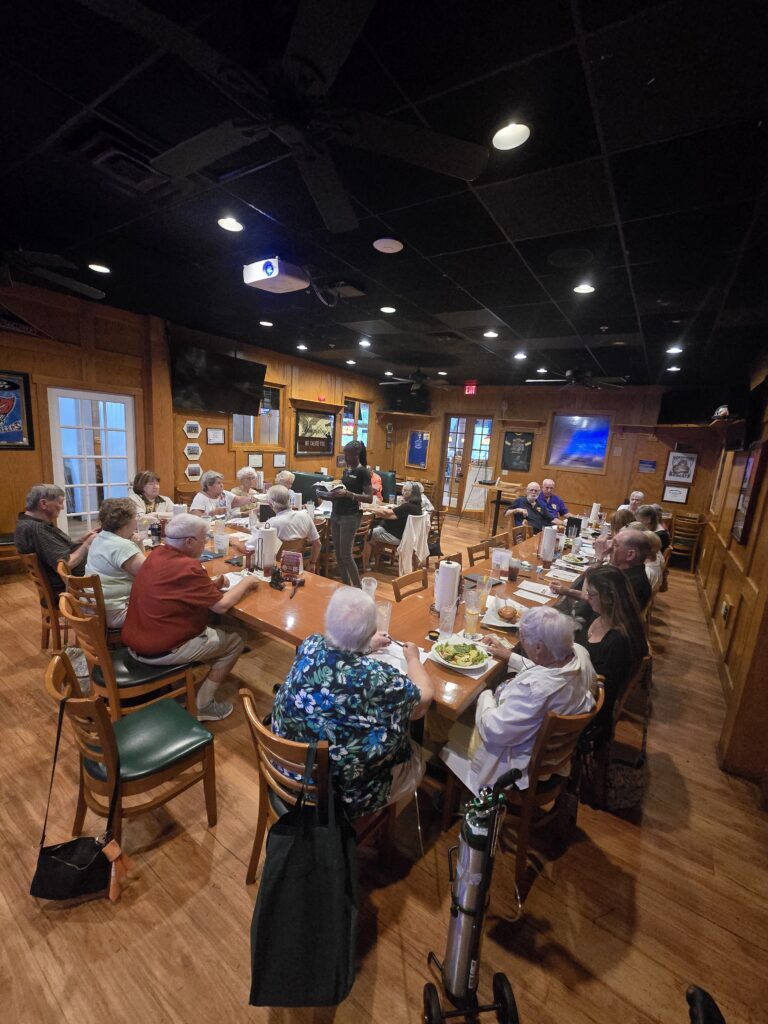 Members of Florida Federation North Port Chapter 1713 gathered around tables during an AI training session.